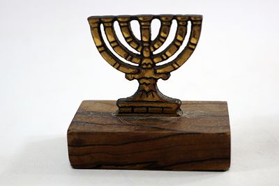 מעמד מנורה מברונזה מיניאטורי מורכב על גבי בסיס עץ זית (שאריות מדבקת מס קניה באחת מפאות הבסיס)