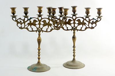 זוג פמוט לשבת לחמשה נרות. פולין, [מִפְנֶה המאות ה-19-20].
פליז יצוק וחרוט.
הקנים ניצבים על 