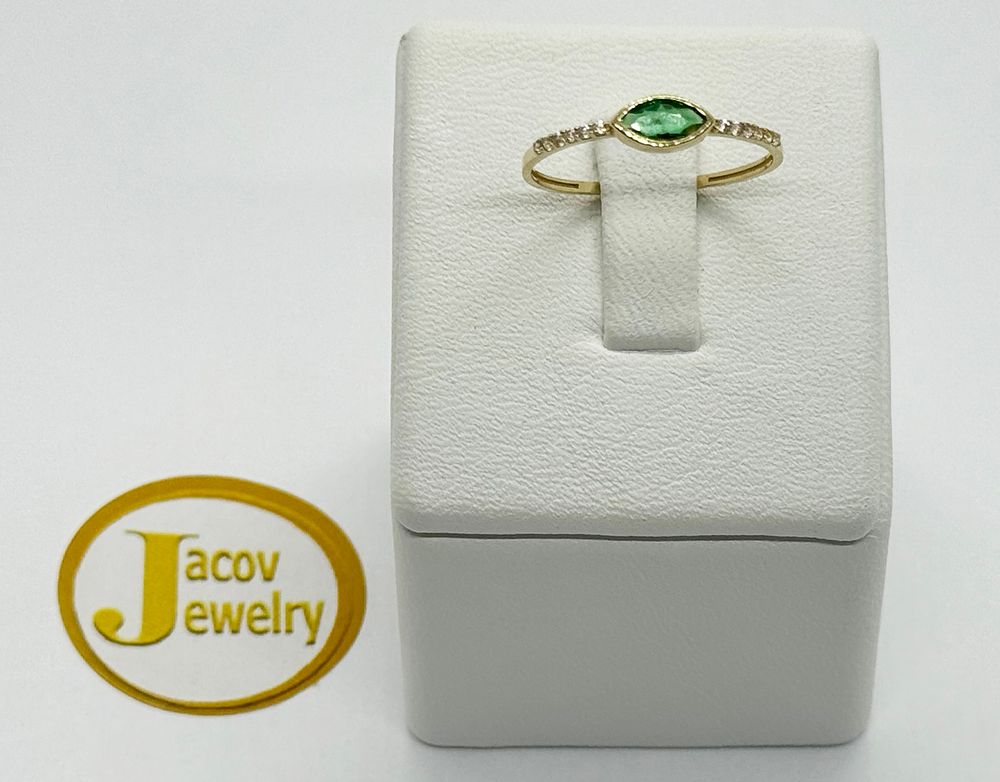 A green marquise eye model ring studded with zircon stones
New 14K yellow gold.... Gold metal 