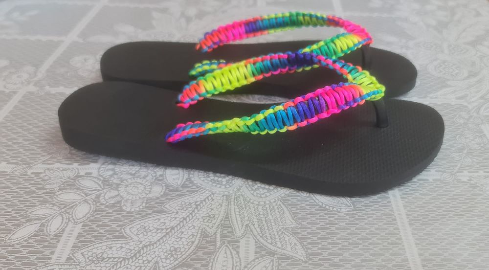 A pair of colorful black Viens flip flops designed by hand with silk threads combined with 