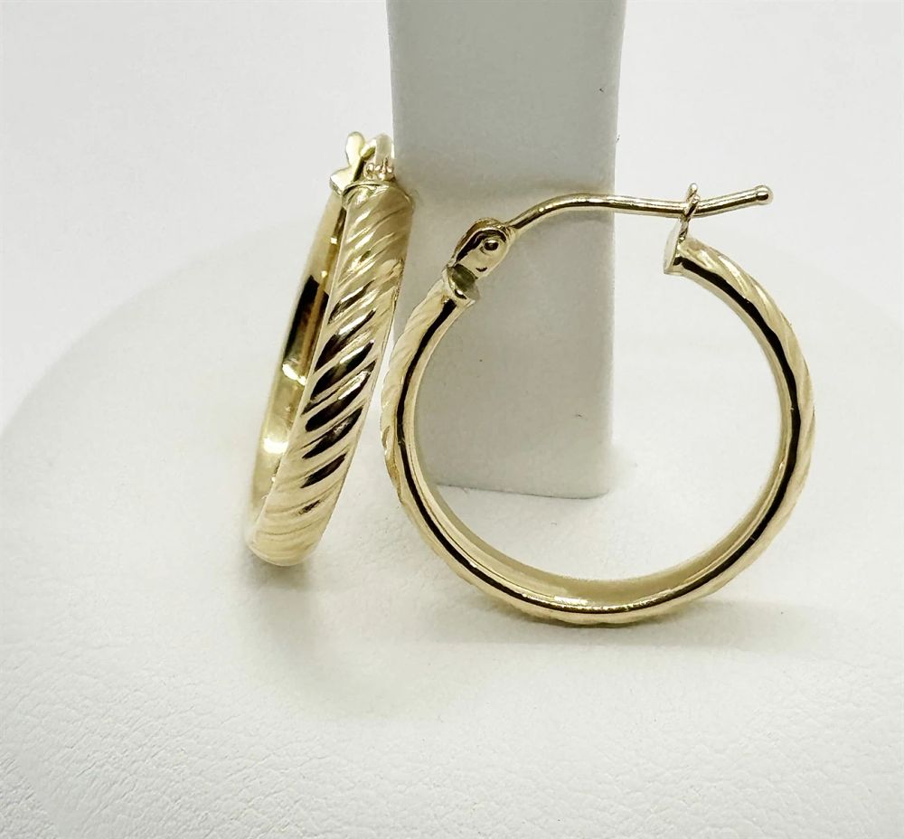 A pair of hoop earrings with a striped design, 
diameter 18 mm, in 14K yellow gold. A pair of 