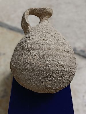 כד חרס. Ceramic juglet with ribbed body and single lug handle; chip missing from rim and neck; a 