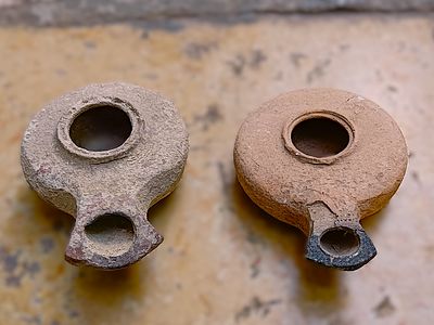 שני נרות חרס הרודיאניים. Lot of two Herodian lamps; round bodies with spatulated nozzles; one 