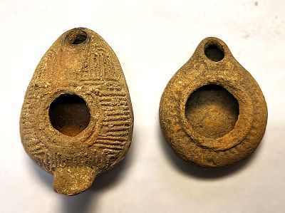 שני נרות חרס. Lot of two terracotta lamps: a. round lamp with large filling hole surrounded by 