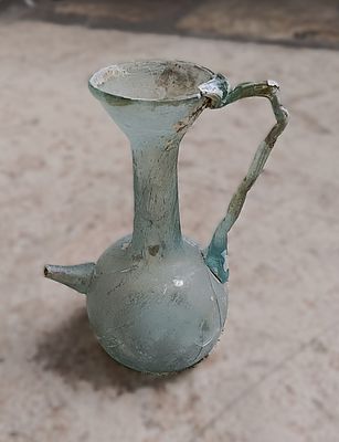 כלי זכוכית עתיקה. Jug with handle and spout; everted rim; concave base; 13.0 x 9.5; hairline 