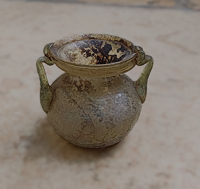 כלי זכוכית עתיקה. Squat jar with two handles, slightly everted rim below which ridge; depressed 