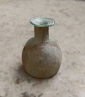 כלי זכוכית עתיקה. Bottle with short neck, rounded body with flat base pushed inwards; slightly 