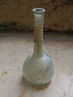 כלי זכוכית עתיקה. Bottle with long neck, thickened rim trailing on neck, 13 x 7 cm Roman; Dr. 