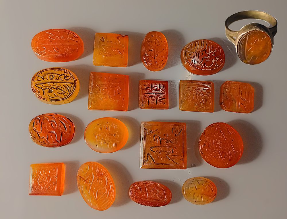 18 Carnelian gemstones inscribed in Arabic and Persian with names and amuletic formulae. One 