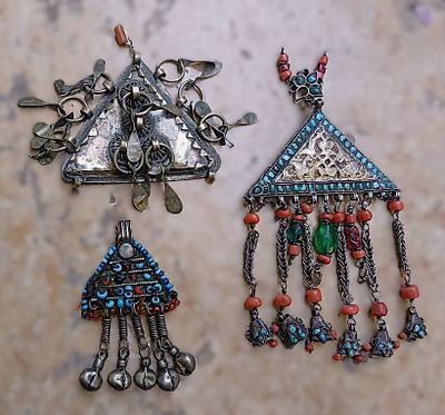 Three pendants in the form of triangular amulet holders made of silver, turquoise, coral and 