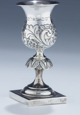 A Silver Kiddush Goblet. A SILVER KIDDUSH GOBLET. Warsaw, 1869. On square base with skirted stem 