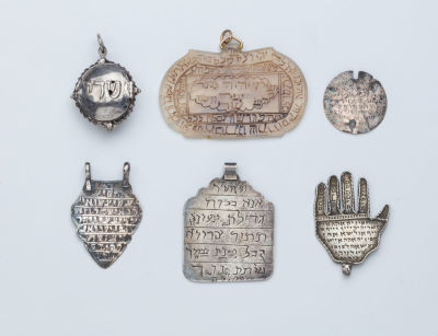 A Group of Six Amulets. A GROUP OF SIX AMULETS. Middle Eastern, c. 1900. Various shapes and sizes.