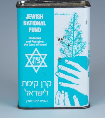 A JNF CHARITY COLLECTION BOX.Israel, c. 1970. The front with a picture of a hand holding a tree 