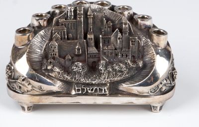 A STERLING SILVER HANUKKAH LAMP BY HENRYK WINOGRAD. New York, 1988. Decorated with a scene of 