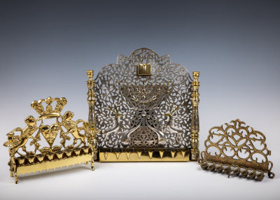 37. A GROUP OF THREE BRASS MENORAHS. Various sizes and origins. Including two in polish style 