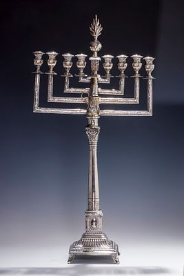 A LARGE SILVER HANUKKAH MENORAH. Warsaw, early 20th century. On a candlestick base that connects 