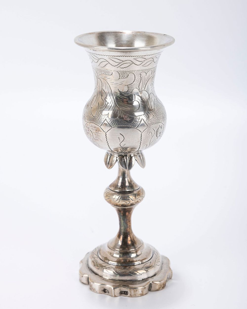 A SILVER KIDDUSH GOBLET. Vilna, 1879. On a stylized base with knobbed stem and skirted 