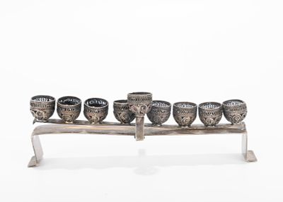 A MINIATURE SILVER MENORAH. Probably Israel, c. 1970. On a rectangular base with eight filigree 