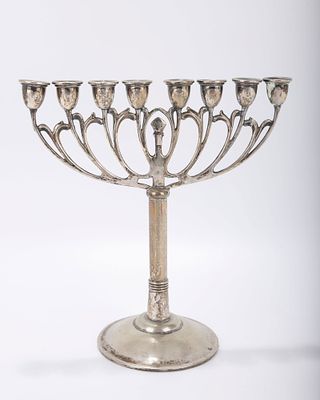 A SILVER HANUKKAH MENORAH. Vienna, c. 1920. On a round domed base with scrolling upper portion. 
