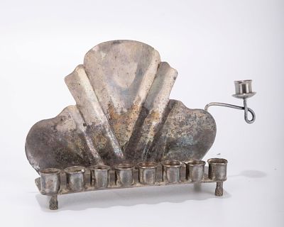 A MINIATURE SILVER MENORAH. Probably Israel, c. 1970. On a rectangular base with eight candle 