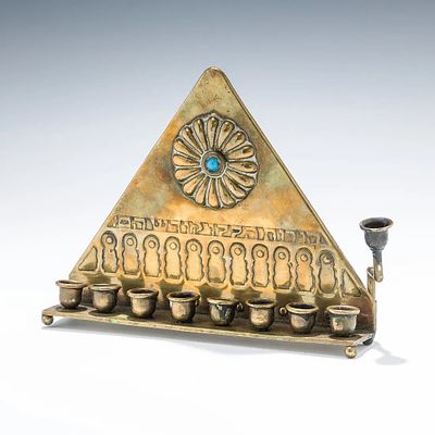 AN EARLY BRASS BEZALEL HANUKKAH LAMP. Jerusalem, c. 1910. Triangular in form. Embossed in 