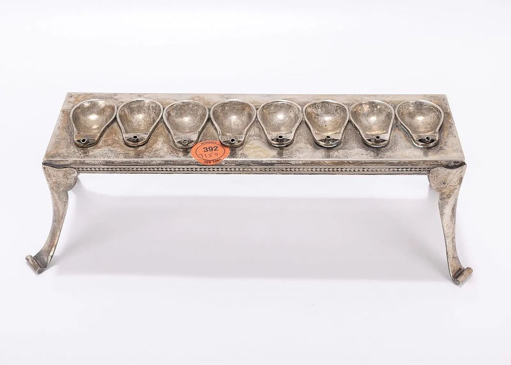 A TABLE FORM SILVER HANUKKAH LAMP. Germany, 19th century. On four tall feet that connect to a 