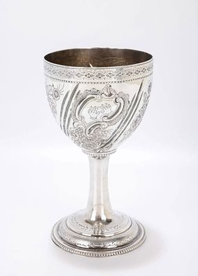 AN ORNATE SILVER KIDDUSH GOBLET. Probably the United States, c. 1920. On a beaded round base 