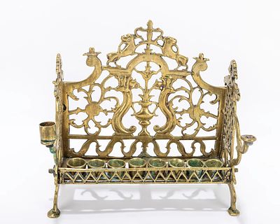 A LARGE BRASS HANUKKAH LAMP. Poland, c. 1880 On four feet with pierced backplate decorated with 