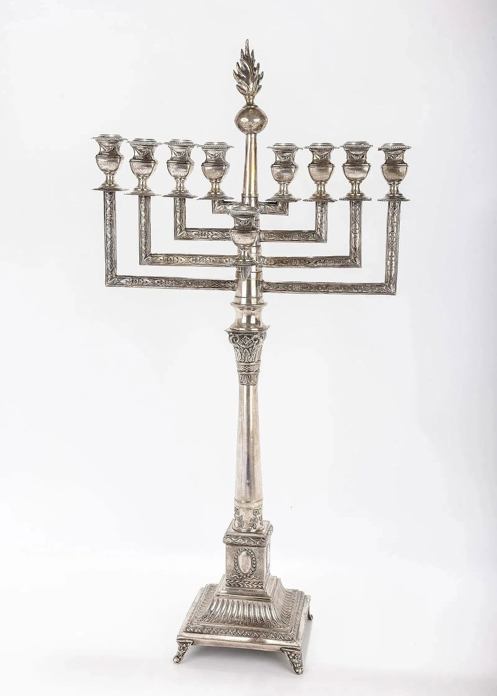 A LARGE SILVER MENORAH. Warsaw, c.1900. On an ornately decorated base in candlestick form. With 