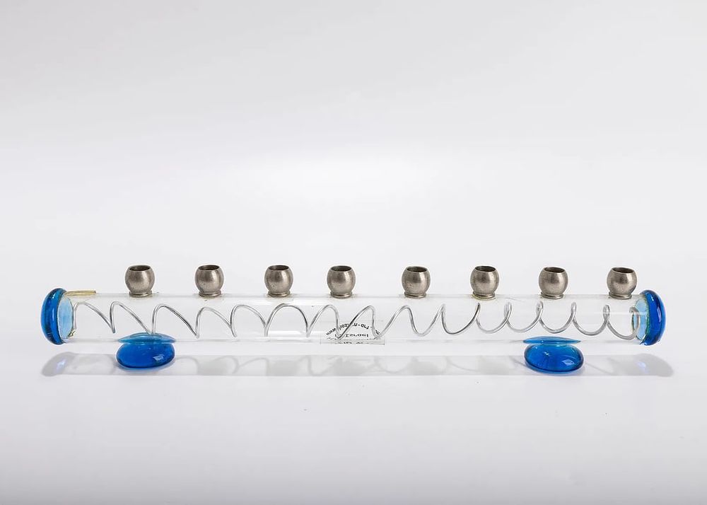 A GLASS HANUKAH LAMP BY HOSHEN. Israel, 20th century. Made of tubular glass with 9 candle 