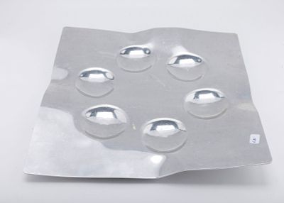 A HAND WROUGHT ALUMINUM SEDER TRAY BY LAURA COWAN MOONSCAPE. Israel, c. 1990. Square in shape. 