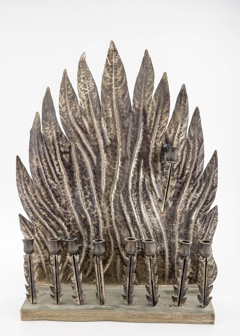 A HANDMADE HANUKKAH LAMP BY S.M. SHALY. Jerusalem, c. 1990. Hand wrought. In the shape of flame. 