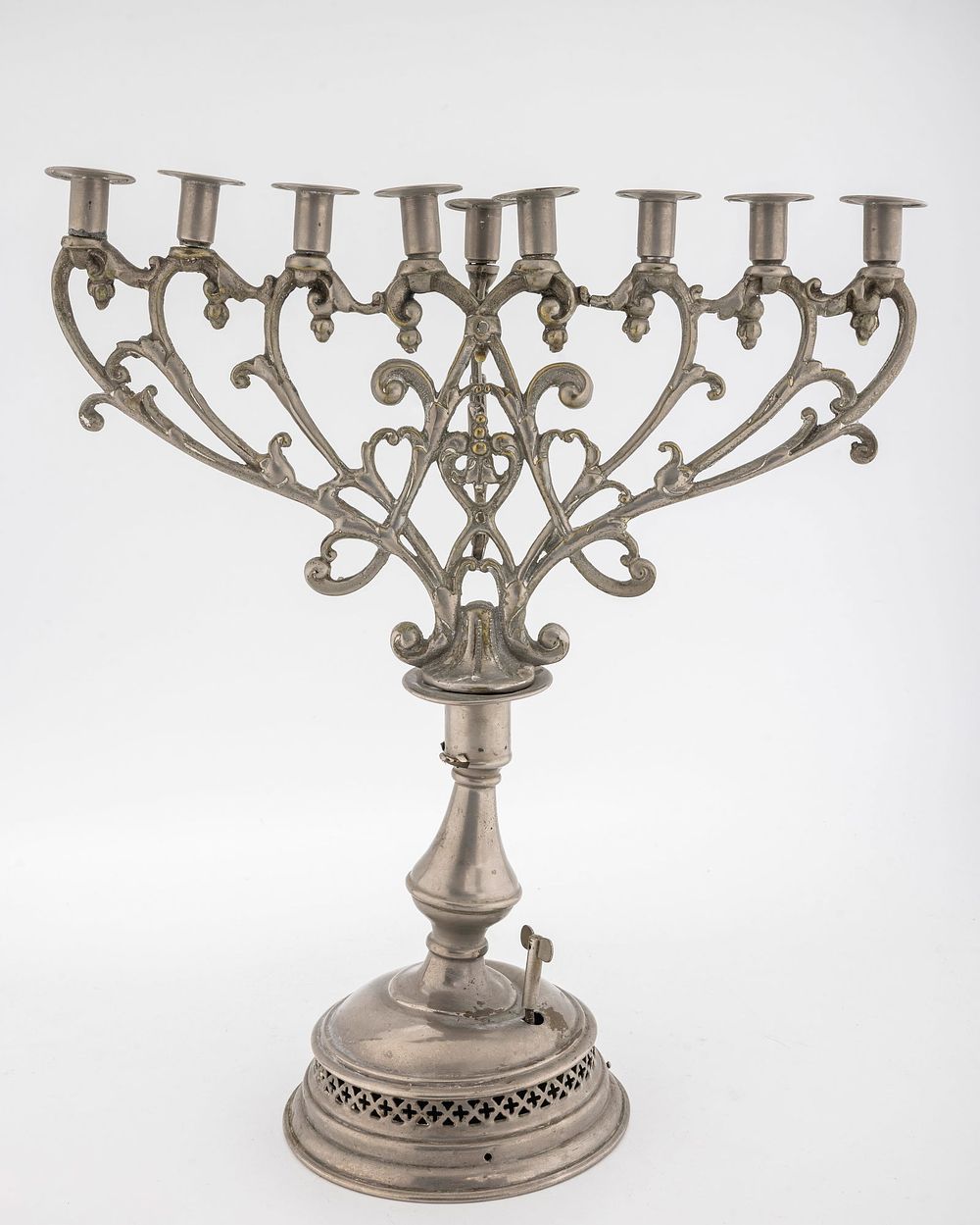 A PEWTER HANUKKAH MENORAH. Germany, c. 1900. On a round base with a non-working music box 