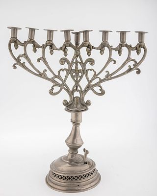 A PEWTER HANUKKAH MENORAH. Germany, c. 1900. On a round base with a non-working music box 