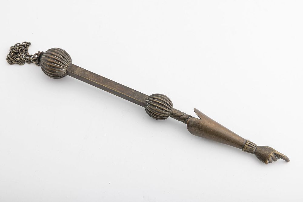 AN EARLY TORAH POINTER. Poland, c. 1840. Brass. The grip with striations and with a cuffed hand 