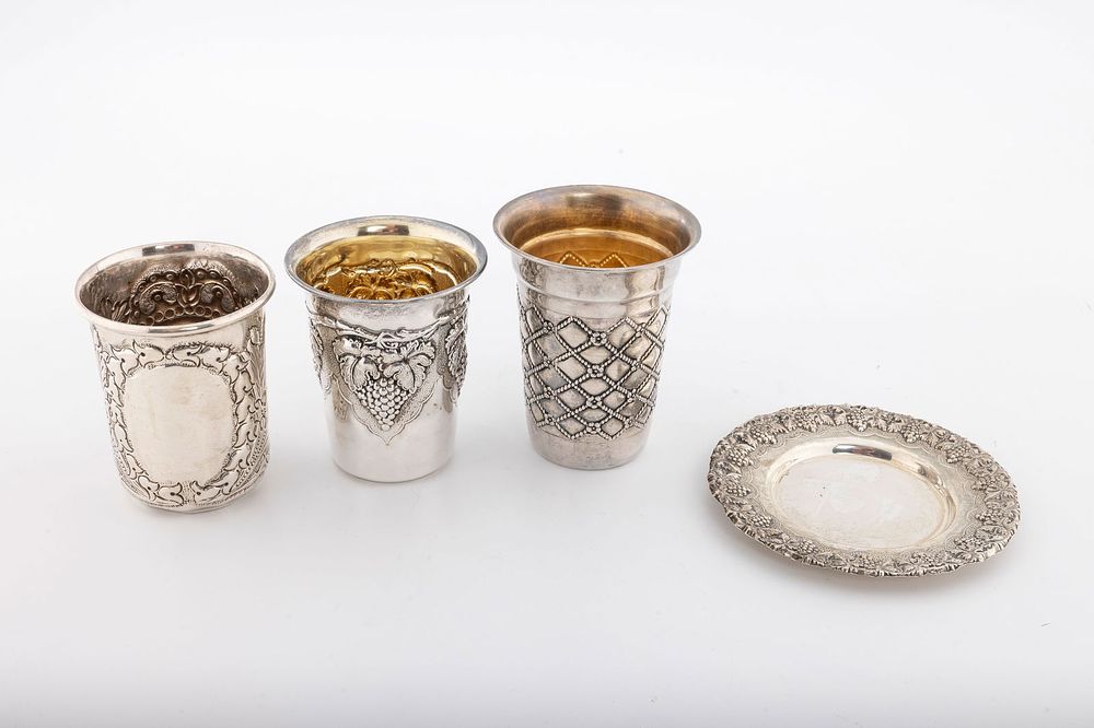 A GROUP OF THREE STERLING SILVER KIDDUSH CUPS. Beaker form. One with a matching plate. Total 