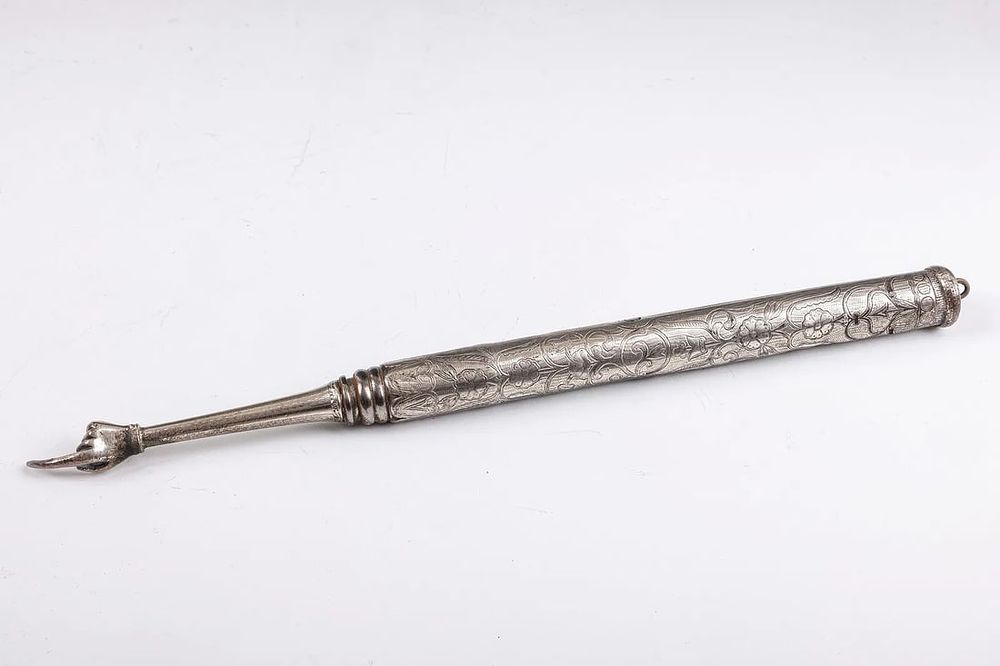 A SILVER TORAH POINTER. Continental, 19th century. Of heavy form. Hand engraved with flowing 