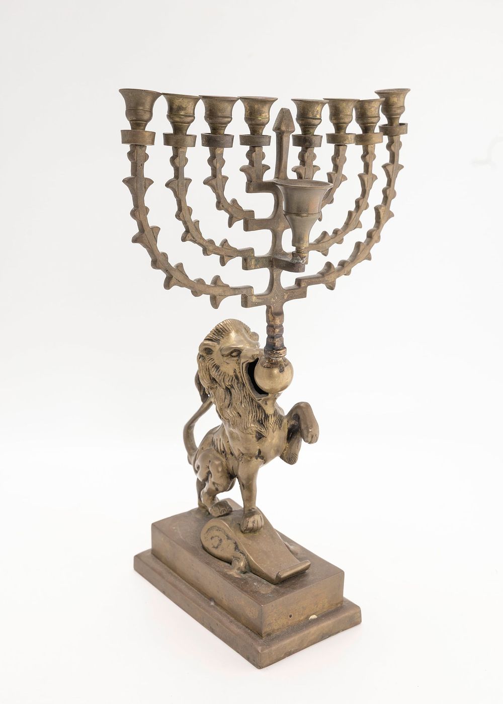 A LARGE BRASS LION FORM MENORAH. Probably Dutch, Early 20th century. On a rectangular base with 