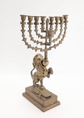 A LARGE BRASS LION FORM MENORAH. Probably Dutch, Early 20th century. On a rectangular base with 