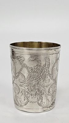 AN ANTIQUE SILVER CUP. Russia, 1786. Beaker form. Engraved with eagle scenes, organic designs 