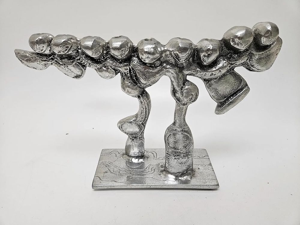 A LARGE ALUMINUM MENORAH SCULPTURE BY DON DRUMM (American, b. 1935). Abstract in design on 