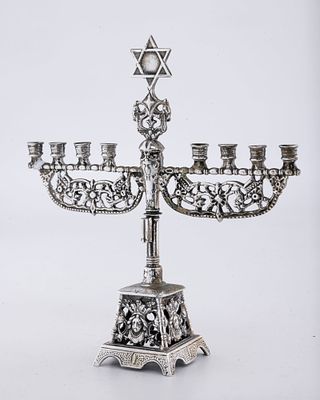 A SILVER MINIATURE MENORAH. The Netherlands, c. 1920. Traditional shape. Marked 5" tall