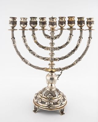 A LARGE SILVER HANUKKAH MENORAH. Portugal, c. 1960. On a hand chased domed base. With eight 