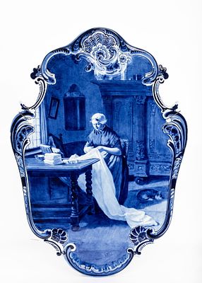 A LARGE ANTIQUE DELFT WALL PLATE AFTER A PAINTING BY NAAR CONSTANT ARTZ. Depicting a seamstress 