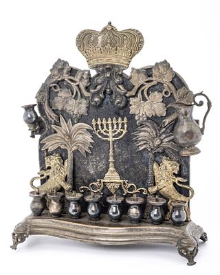 A BRASS HANUKKAH LAMP. Warsaw, c. 1880. The back plate is decorated with two lions each 