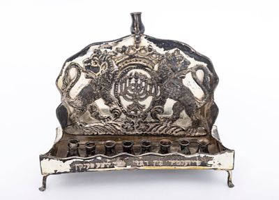 AN ANTIQUE STERLING SILVER HANUKKAH LAMP- MENORAH, NEW YORK, C. 1920. On four fee and a sofa 