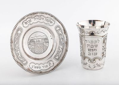 A STERLING SILVER KIDDUSH CUP AND UNDERPLATE BY SHUKI FRIEMAN. Israel, c. 1990. Engtraved with 