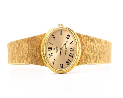 AN 18K GOLD LADIES WATCH BY UNIVERSAL GENEVE. Golden shadow, quartz.8.1" long and 81.7 grams 