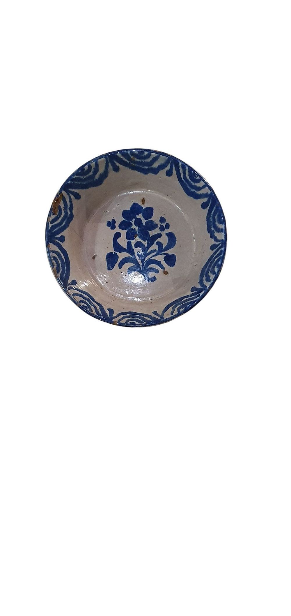 Fuente o lebrillo, S. XIX. Cerámica de Fajalauza - Granada, vidriado o esmaltado en blanco y azul representando una flor rodeada de ramilletes de capullos y ondas en los bordes., lote 77