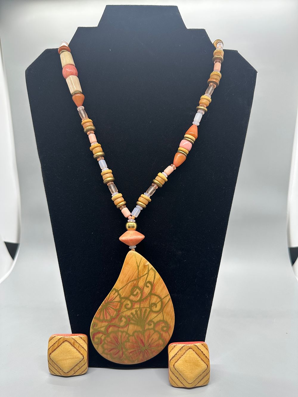 Beaded Necklace with Floral Wooden Pendant and Matching Earrings. A beaded necklace featuring a 